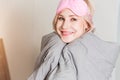 Positive woman with pillow sitting in bed and smiling to camera at home Royalty Free Stock Photo