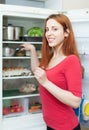 Positive woman putting pan into refrigerator Royalty Free Stock Photo