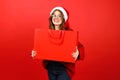 Positive woman in santa hat with red bag in her hands, christmas discounts. Buy and give Christmas gifts