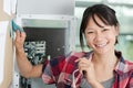 positive woman sticking sticky notes on wall chart