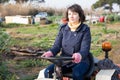 Positive woman working on small farm tractor Royalty Free Stock Photo