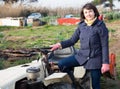 Positive woman working on small farm tractor Royalty Free Stock Photo