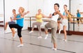 Women practicing vigorous dance movements in group dance class