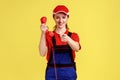 Positive worker woman standing with landline phone in hands, pointing finger to camera. Royalty Free Stock Photo