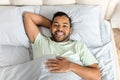 Positive young african american man laying in bed Royalty Free Stock Photo
