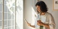 Positive young brunette caucasian woman smiles looking at her smartphone screen indoors. Royalty Free Stock Photo