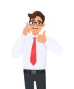 Positive young business man in formal speaking/talking on the mobile, cell or smart phone. Person gesturing, making thumbs up sign Royalty Free Stock Photo