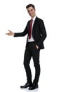 Positive young businessman presenting and standing Royalty Free Stock Photo