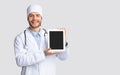 Positive young doctor showing digital tablet with blank screen Royalty Free Stock Photo