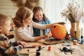 Smiling mother with children creating jack-o-lantern during Halloween celebration at home Royalty Free Stock Photo