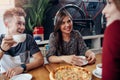 Positive young friends having a lunch break at stylish retro cafe. Boy and girls having a great time together, talking Royalty Free Stock Photo