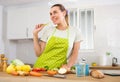 Positive young girl enjoying vegetable salad in home kitchen Royalty Free Stock Photo