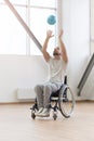 Positive young handicapped playing the ball in the gym