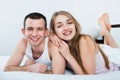 Positive young happy adults lying in family bed