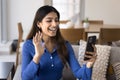 Positive young Indian blogger woman waving hand at smartphone Royalty Free Stock Photo