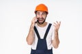 Positive young man builder talking by mobile phone