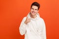 Positive young man in hoody with stylish hairdo showing thumbs up and sincerely smiling. Well done