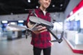 positive young man with a quadcopter in his hands is in the drones store. Buy a dron at an electronics store