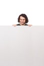 Positive young man, standing behind a big blank banner looking down contented at the copy space message. Cheerful male and an Royalty Free Stock Photo