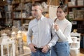 Positive young married couple choosing new garden furniture in furniture store Royalty Free Stock Photo