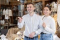 Positive young married couple choosing new garden furniture in furniture store Royalty Free Stock Photo