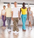 Positive young multinational people forming line while rehearsing traditional Irish stepdance in dance studio Royalty Free Stock Photo