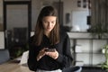 Positive young professional girl chatting on smartphone in office alone Royalty Free Stock Photo