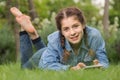 young girl using digital tablet while lying in green spring garden Royalty Free Stock Photo