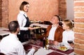 Waitress placing order in front of guests Royalty Free Stock Photo