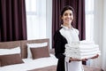 Positive young woman bringing fresh white towels Royalty Free Stock Photo