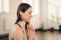 Positive young woman doing namaste hand gesture at studio