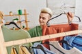 positive young woman holding hangers with Royalty Free Stock Photo