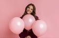 Positive girl posing with three rosy baloons, standing over pink background Royalty Free Stock Photo