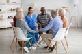 Positive young woman psychologist having group therapy with senior people Royalty Free Stock Photo