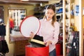 Saleswoman preparing hats in boxes for sale