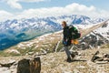 Positive young woman tourist climber with backpack sunglasses climbed to the top of the mountain against the backdrop of a green v