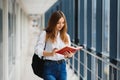 Positivity beautiful girl smiling at camera, standing on corridor with notes as backpack, going to lesson. Happy brunette female Royalty Free Stock Photo