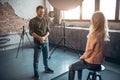 Positive photographer telling jokes to a blond model after photo session Royalty Free Stock Photo