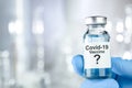 Possible cure with a hand in blue medical gloves holding Coronavirus, Covid 19 virus, vaccine vial Royalty Free Stock Photo