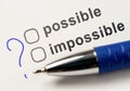 Possible or impossible, choice in checkbox. possible and impossible options, question mark and pen on white paper background Royalty Free Stock Photo