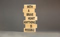 Possible symbol. Concept words With a brave heart anything is possible on wooden blocks on a beautiful grey table grey background Royalty Free Stock Photo