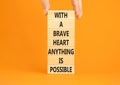 Possible symbol. Concept words With a brave heart anything is possible on wooden blocks on a beautiful orange table orange Royalty Free Stock Photo