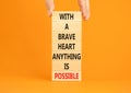 Possible symbol. Concept words With a brave heart anything is possible on wooden blocks on a beautiful orange table orange Royalty Free Stock Photo