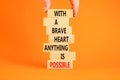 Possible symbol. Concept words With a brave heart anything is possible on wooden blocks on a beautiful orange table orange Royalty Free Stock Photo