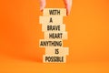 Possible symbol. Concept words With a brave heart anything is possible on wooden blocks on a beautiful orange table orange Royalty Free Stock Photo