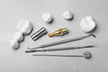 Post, abutment and different crowns of dental implant near medical tools on grey table, flat lay Royalty Free Stock Photo