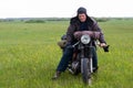 A post apocalyptic man on motorcycle in a meadow Royalty Free Stock Photo