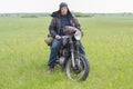 A post apocalyptic man on motorcycle in a meadow Royalty Free Stock Photo