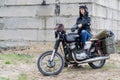 A post apocalyptic woman on motorcycle near the destroyed building Royalty Free Stock Photo