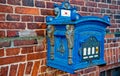 Post box blue color on red brick wall background Royalty Free Stock Photo